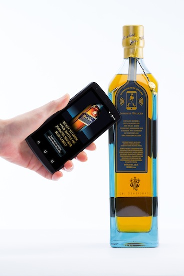 Photo: a user taps the bottle with an NFC smartphone to get information